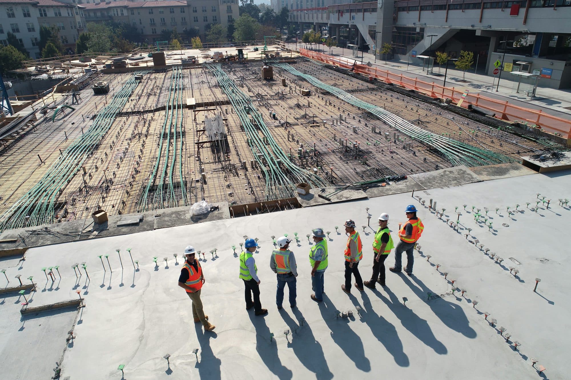 Crew in high-visibility vests standing on a concrete slab at a jobsite